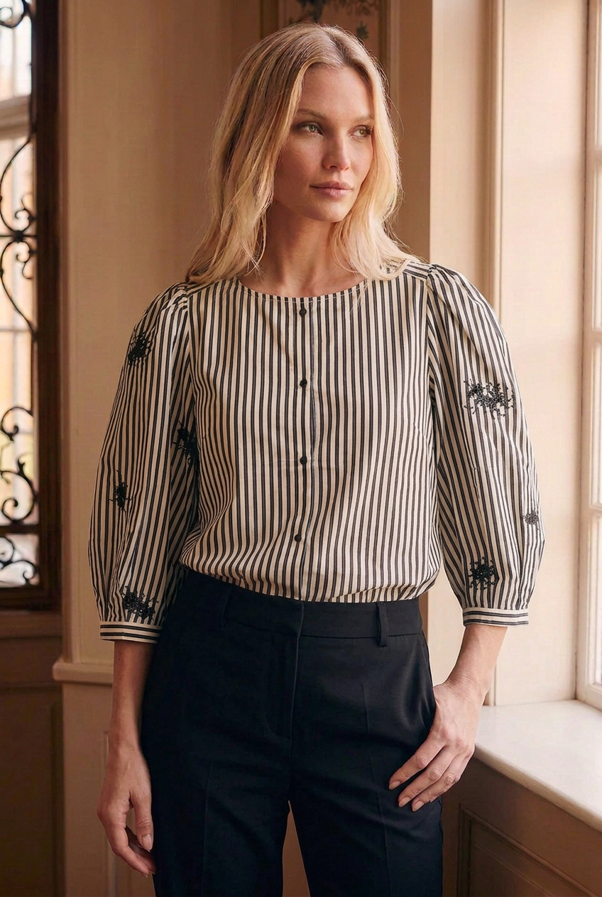 Front view of B Copenhagen striped blouse tucked into black trousers