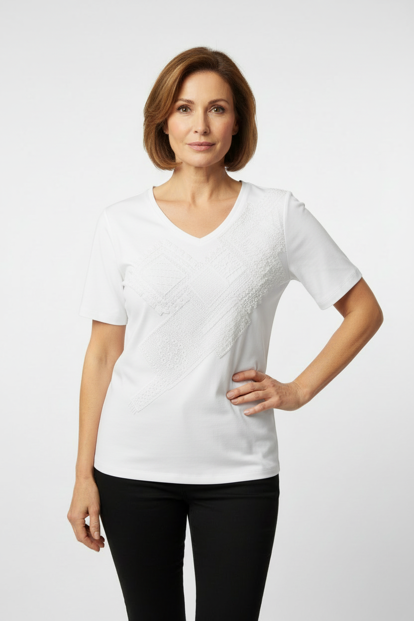 Mature model wearing white embellished top with shorter sleeves