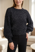 Fluffy black knit with silver threads shown on a model in soft directional light