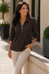 Model wearing the dark-brown version of the collared half-zip top