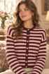 Upper body lifestyle model image of the burgundy and pink striped cardigan